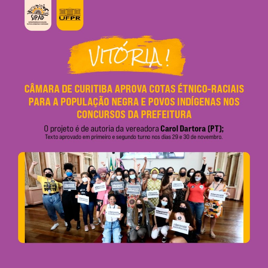 Card de divulgação de matéria jornalística. 

Em fundo roxo, lê-se a manchete: Vitória! Câmara de Curitiba aprova cotas étnico-raciais para a população negra e povos indígenas nos concursos da prefeitura. Logo abaixo, lê-se a submanchete: O projeto é de autoria da vereadora Carol Dartora (PT); Texto aprovado em primeiro e segundo turno nos dias 29 e 30 de novembro.  

Na metade inferior do card, existe uma foto dos envolvidos na proposição do projeto de lei, dentro da câmara de vereadores. No centro, a vereadora Carol Dartora - uma mulher negra, que no momento usava vestido e máscara - está segurando um papel onde se lê “#AprovajáCotasRaciais”. Os outros integrantes do movimento pela aprovação do projeto, que estão ao redor da vereadora, também usam máscaras e seguram um papel com os mesmos dizeres. A maioria das pessoas, incluindo a vereadora, ergue um dos braços com a mão em punho cerrado. 

No topo do card encontram-se as logos da SIPAD e da UFPR.    